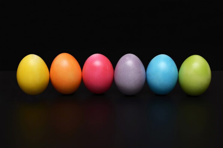 Zes vrolijk gekleurde eieren op een rij