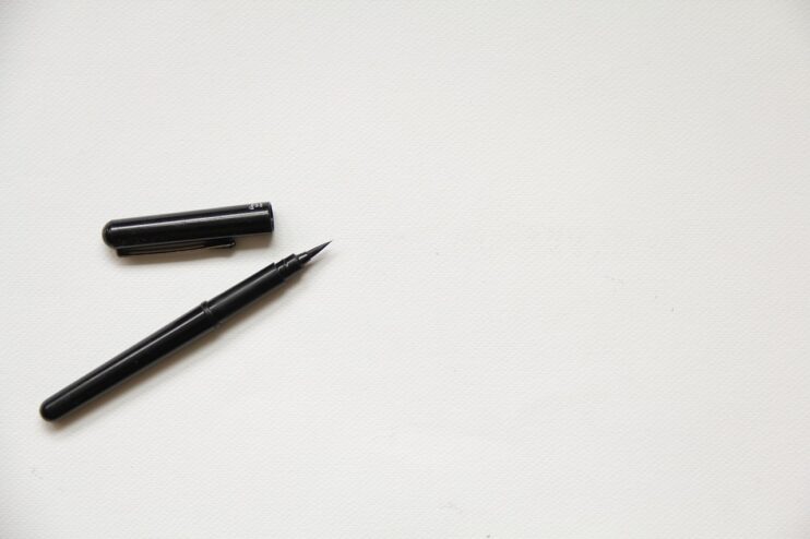 Een pen om een handtekening mee te zetten ligt op een wit vel papier.