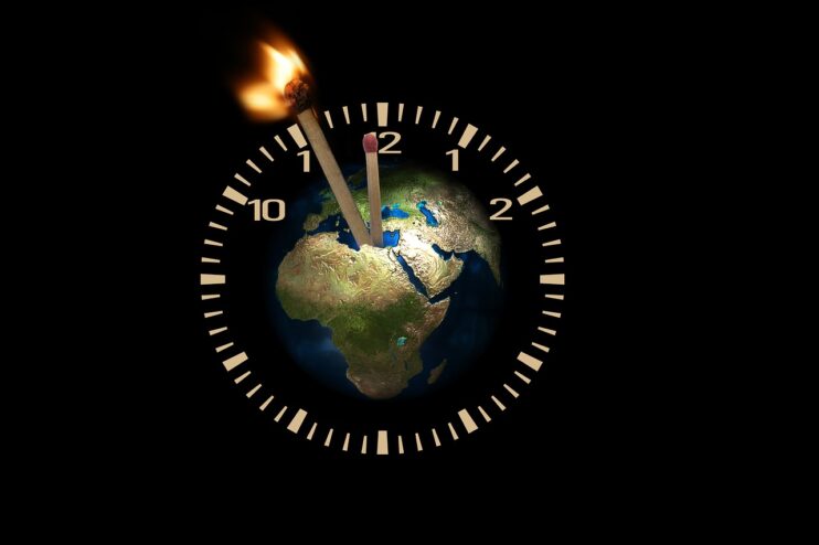 Vijf voor twaalf - Een klok met in het midden de aarde heeft als grote wijzer een brandende lucifer die de kleine wijzer nadert, die ook een lucifer is