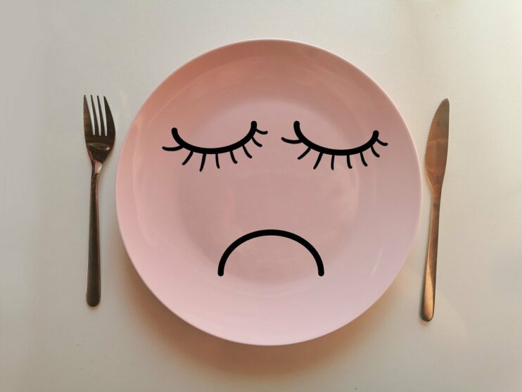 Een extreem dieet, een afbeelding van een leeg bord met een sip gezicht erop getekend, met ernaast een vork en een mes